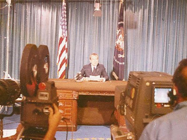 President Nixon seated at a desk delivering his televised resignation speech. 8/8/1974, Washington, D.C.